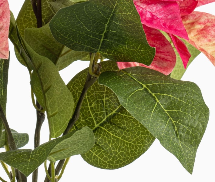 Schwarzer Kunststoff-Blumentopf mit künstlicher Erde und Pflanzenstielen.