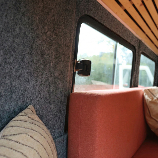 Innenraum eines Fahrzeugs mit Filzwand, Fenster und Sitzbank