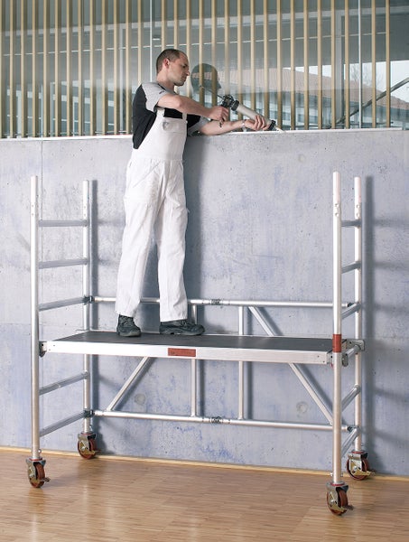 Mann arbeitet mit einer Aluminium Rollrüstung und einer Kartuschenpistole an einer Wand