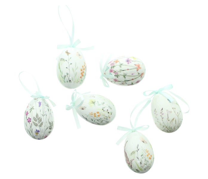 Dekorative Ostereier mit Blumenmuster und Schleifen zum Aufhängen.