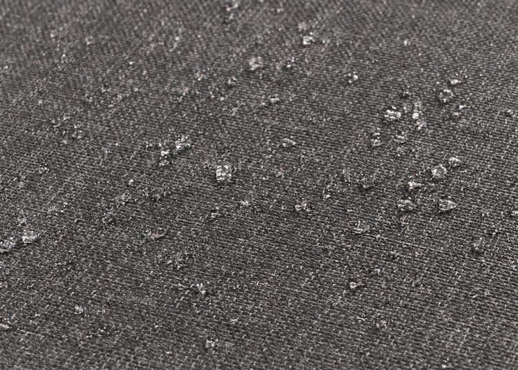 Nahaufnahme eines wasserabweisenden Stoffes mit Wassertropfen