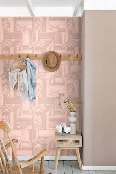 Raumansicht mit gemusterter Tapete, Garderobe mit Accessoires und Beistelltisch mit Blumenvasen