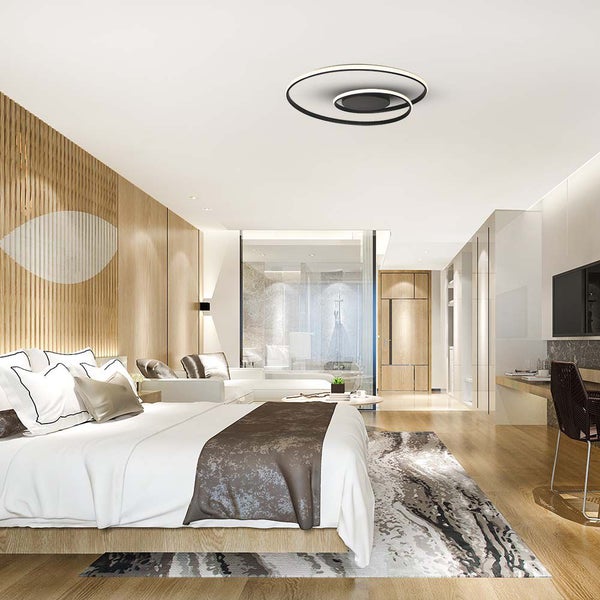 Schlafzimmer mit Bett, Schreibtisch und spiralförmiger Deckenleuchte