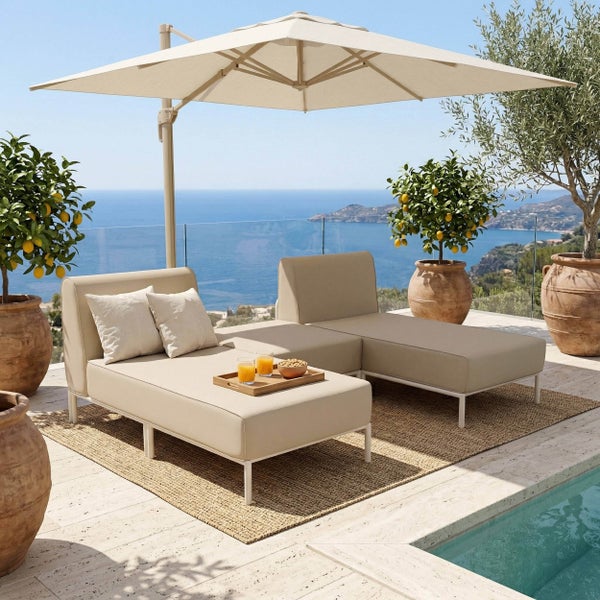 Helle Gartenlounge mit Polsterelementen, Ampelschirm und Zitronenbäumen in Terrakottatöpfen auf einer Terrasse am Pool mit Meerblick.