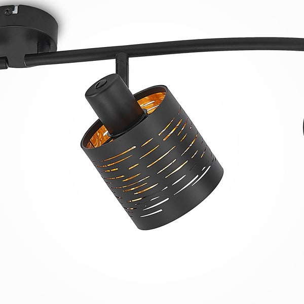 Deckenstrahler aus schwarzem Metall mit dekorativen Aussparungen und goldfarbener Innenseite.