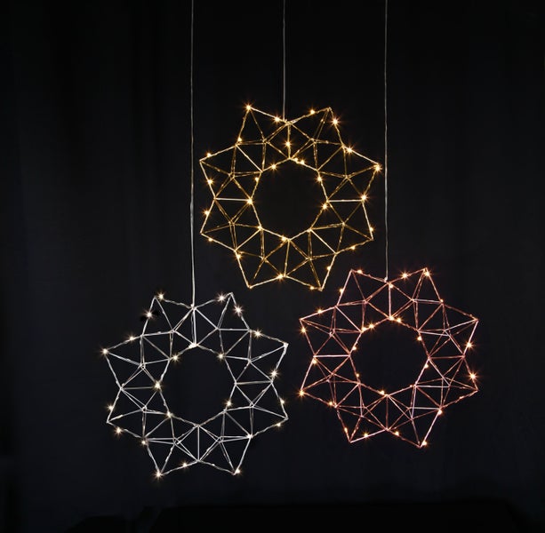 Drei geometrische Weihnachtssterne mit Beleuchtung hängen von der Decke