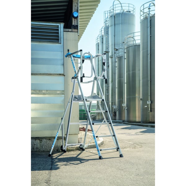 Eine Zarges Treppenplattformleiter steht im Freien vor einem Gebäude.