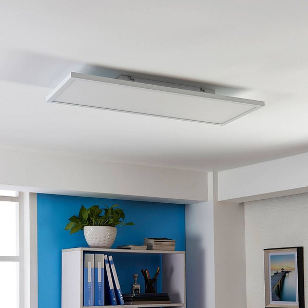 Modernes rechteckiges LED-Panel an der Decke in einem hellen, aufgeräumten Raum über einem Regal mit einer Pflanze.