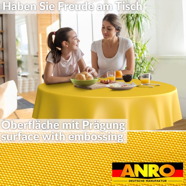 Runde Tischdecke mit geprägter Oberfläche in einer hellen Wohnküche mit einer Frau und einem Kind beim Essen, ANRO Logo.