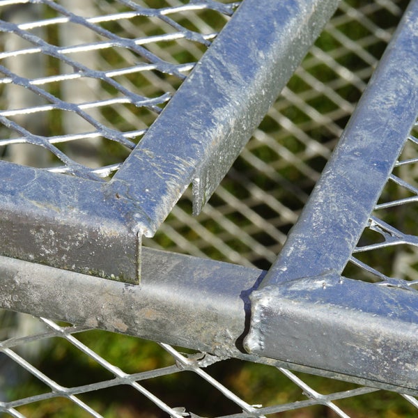 Detailansicht eines Metallzauns mit Gitterstruktur