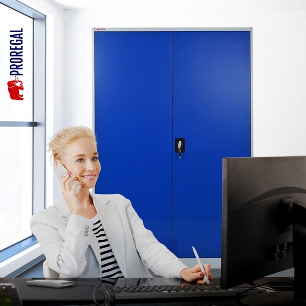 Frau telefoniert am Schreibtisch in einem hellen Büro vor einem Metallschrank. Proregal Logo.