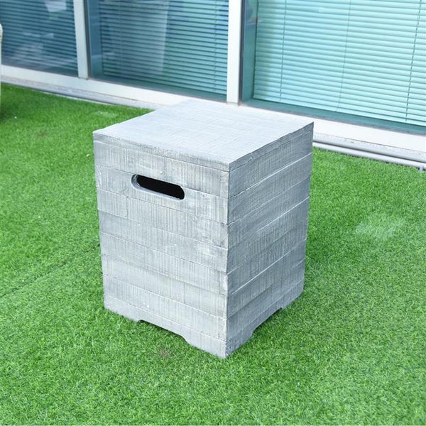 Quadratischer Gartenhocker in Holzoptik mit seitlicher Griffmulde, platziert auf Kunstrasen vor einer Fensterfront.