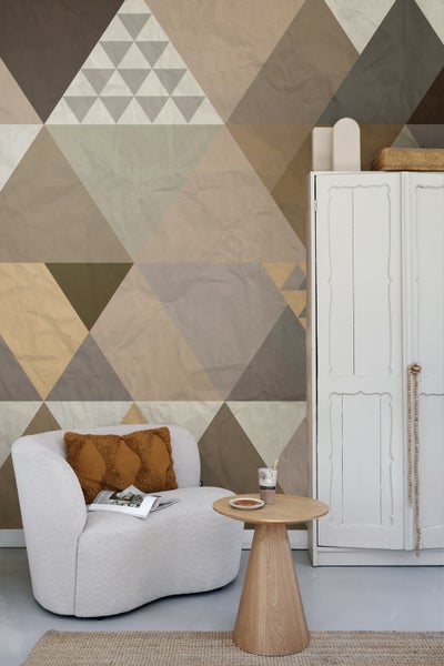 Wohnraum mit geometrischer Tapete, Sessel und Beistelltisch