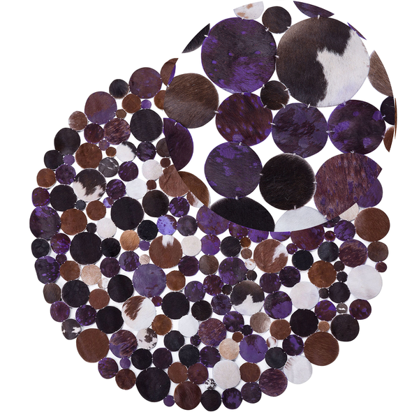 Runder Patchwork-Teppich aus kreisförmigen Kuhfell-Stücken in Violett, Braun, Schwarz und Weiß.