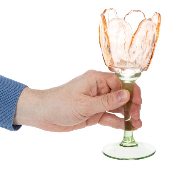 Hand hält einen Kerzenhalter aus Glas