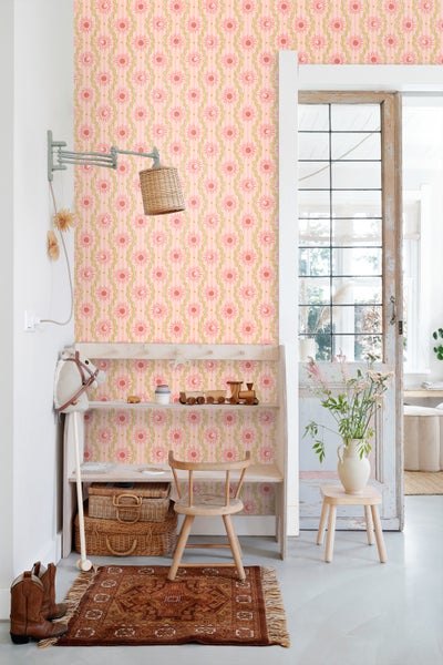 Heller Raum mit rosa Tapete, verziert mit Sonne und Mond Symbolen, ergänzt durch Holzmöbel und dekorative Accessoires.