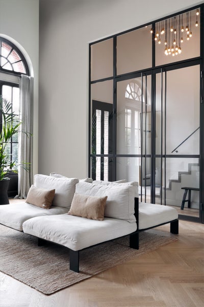 Heller Wohnraum mit Sofa, Teppich und Glastür