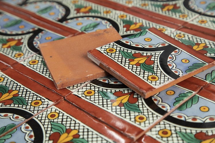 Dekorative Fliesen mit floralem Muster und Terrakotta-Akzenten