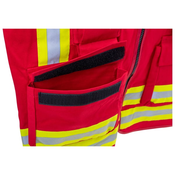 Detailansicht einer Arbeitsjacke mit geöffneter Tasche, Klettverschluss und Reflexstreifen.