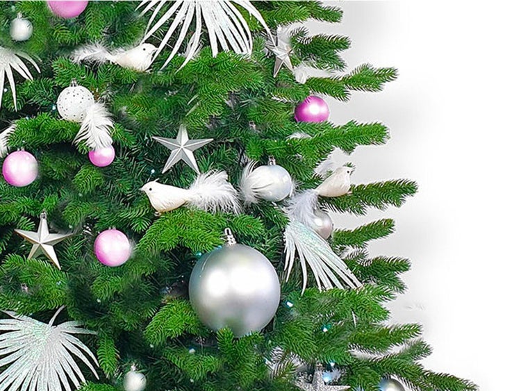 Weihnachtsbaum geschmückt mit Kugeln Sternen und Vogelornamenten in einer festlichen Dekoration.