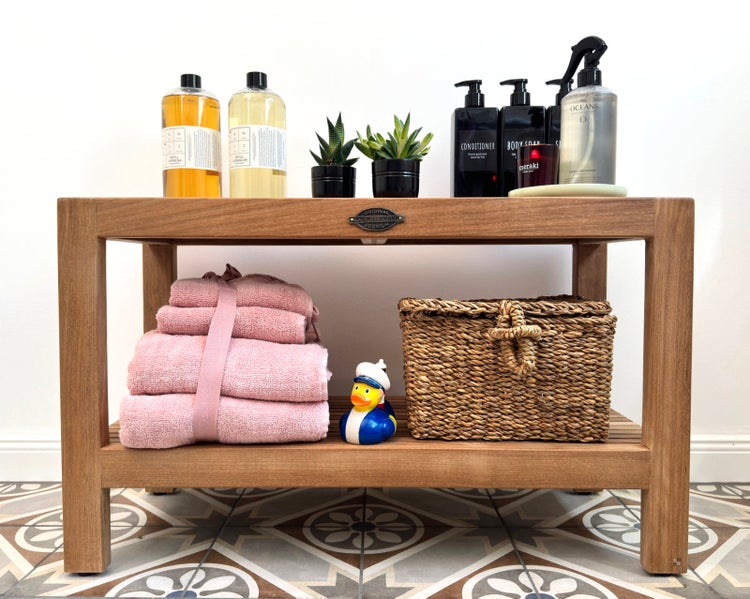 Badezimmerablage aus Holz mit Handtüchern, Korb, Badeente und Pflegeprodukten