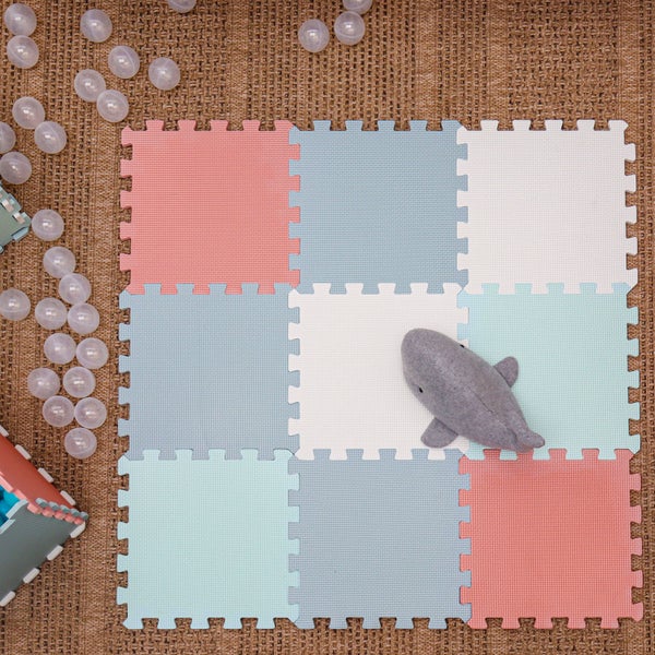 Bunte Schaumstoff Puzzlematte für Kinder mit ineinandergreifenden Quadraten und einem ausgestopften Hai Spielzeug auf einem Bodenbelag