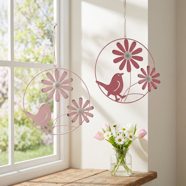 Zwei runde Metall Hängedekorationen mit Vogel und Blumenmotiven zur Fensterdekoration im Frühling.