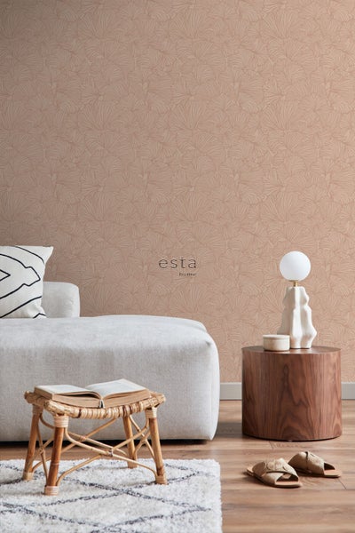 Wohnzimmer mit Vliestapete mit Ginkgo Blätter Muster, Esta Home Logo, Sofa, Beistelltisch und Dekoration in moderner Einrichtung.