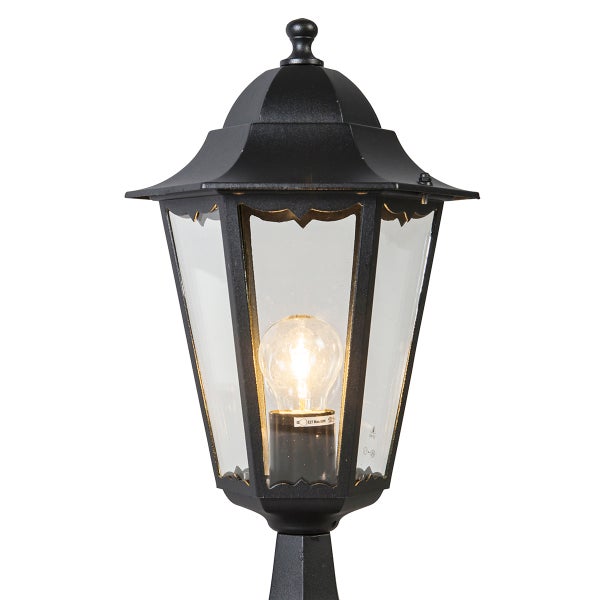 Klassische Außenleuchte in Laternenform aus schwarzem Metall mit klaren Glaseinsätzen und sichtbarem Leuchtmittel.