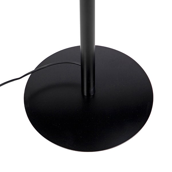 Runder schwarzer Metallfuß einer Stehleuchte mit zylindrischem Standrohr und Stromkabel.