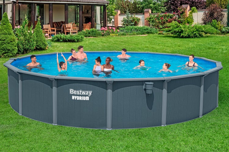 Rundes Bestway Hydrium Stahlwandbecken in einem Garten, in dem Erwachsene und Kinder baden.
