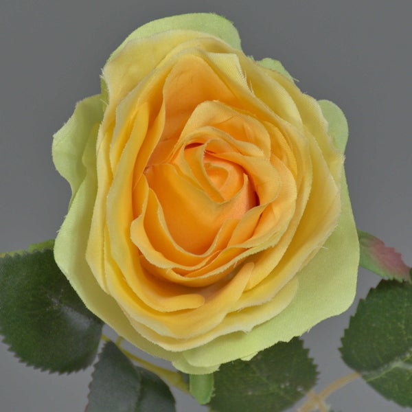 Künstliche gelbe Rose aus Textil mit grünen Blättern.
