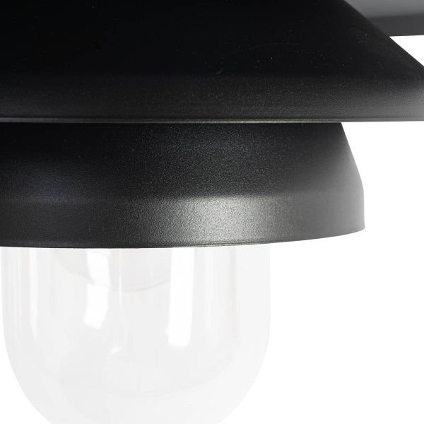 Nahaufnahme einer schwarzen Lampe mit abgestuftem Schirm und klarem Glas.