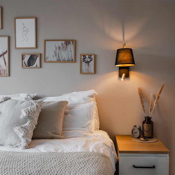 Schlafzimmer mit Bett, Nachttisch und Wandleuchte