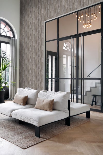 Wohnzimmer mit Sofa, Teppich und gemusterter Tapete