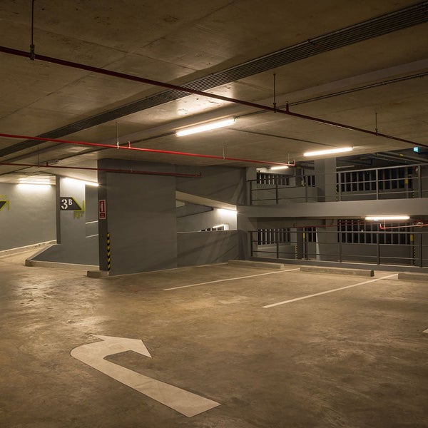Parkhausinnenraum mit Betonboden und Decke sowie Parkmarkierungen und Pfeilen