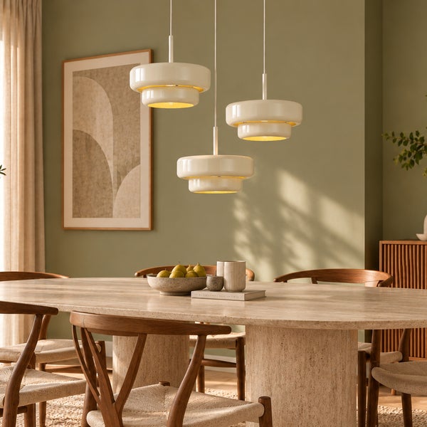 Drei moderne Pendelleuchten über einem Esstisch aus Stein mit Stühlen aus Holz in einem wohnlichen Esszimmer.