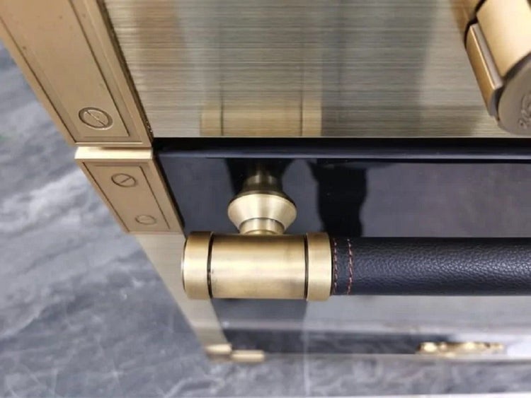 Backofentürgriff mit Lederummantelung und metallischen Endstücken an einem Backofen mit Metallrahmen