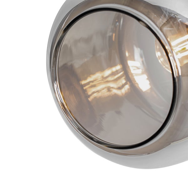 Detailansicht eines runden Lampenschirms aus Glas mit spiegelnder Oberfläche und sichtbarem Leuchtmittel im Inneren.