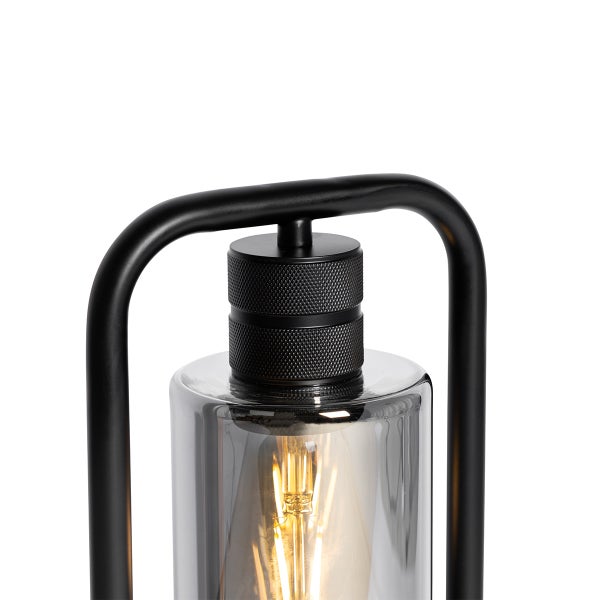 Detailaufnahme einer Tischleuchte mit Metallrahmen und Glaszylinder