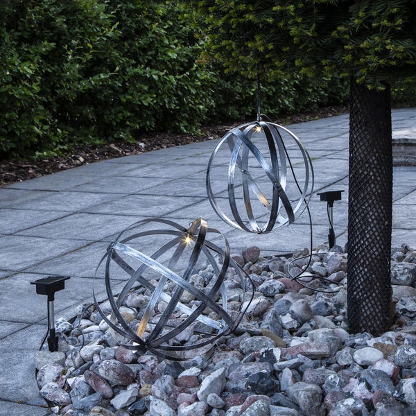 Zwei dekorative Metallkugeln mit Solarleuchten im Garten