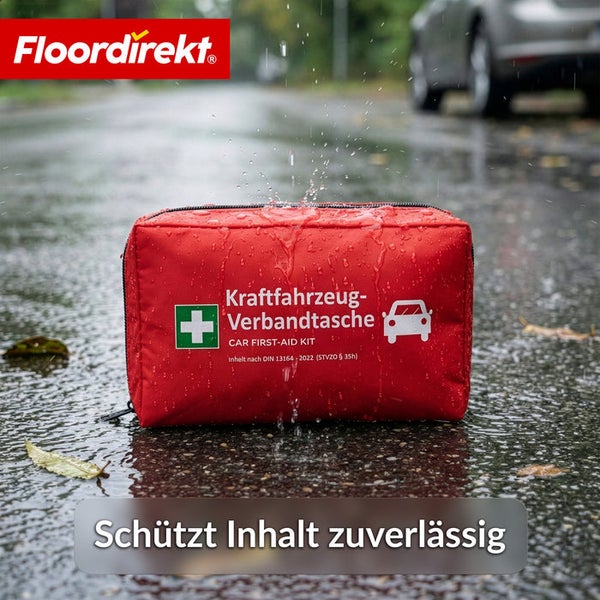Floordirekt Logo. Wasserabweisende Kraftfahrzeug-Verbandtasche im Regen auf nassem Asphalt, schützt den Inhalt zuverlässig vor Nässe.