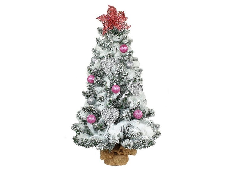 Künstlicher, beschneiter Weihnachtsbaum im Jutesack mit festlichem Schmuck wie Kugeln, Herzen und Sternspitze