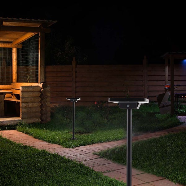 Beleuchteter Garten mit zwei Solarleuchten und Gartenhaus