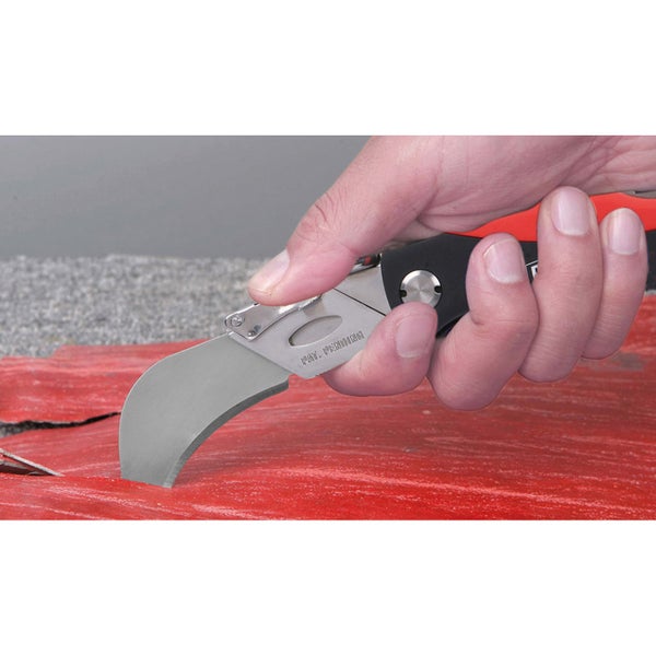 Hand, die ein Teppichmesser zum Schneiden von Materialien hält