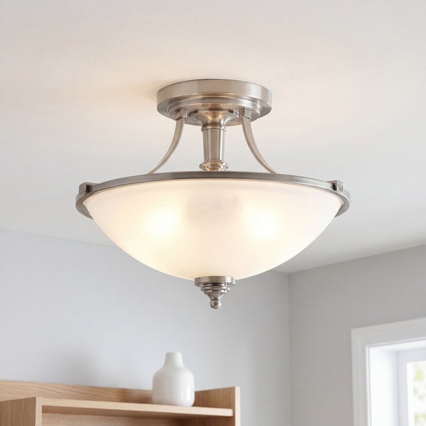 Klassische halbbündige Deckenleuchte mit gebürstetem Metallgestell und schalenförmigem Schirm aus satiniertem Glas, eingeschaltet.