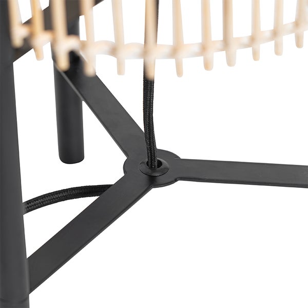 Detailansicht einer Lampe mit schwarzem Metallfuß und Lampenschirm aus Rattan