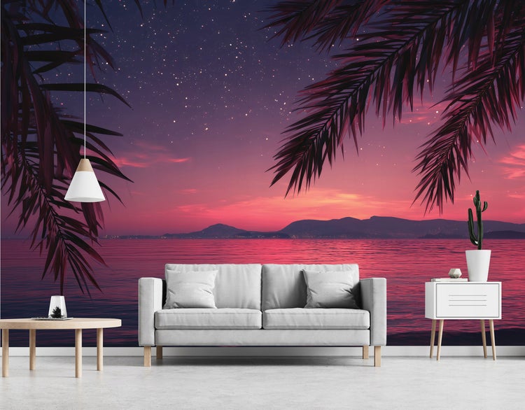 Wohnzimmer mit Tapete, die einen Sonnenuntergang am Meer mit Palmen darstellt, Sofa, Tisch und Lampe.