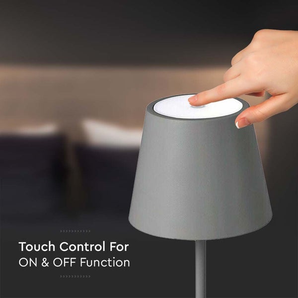 Graue Tischleuchte mit Touch-Funktion wird mit einem Finger bedient