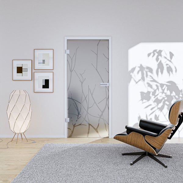 Moderne Ganzglastür mit Ast-Dekor in einem hellen Wohnzimmer mit Lounge-Sessel, Stehleuchte und grauem Teppich.